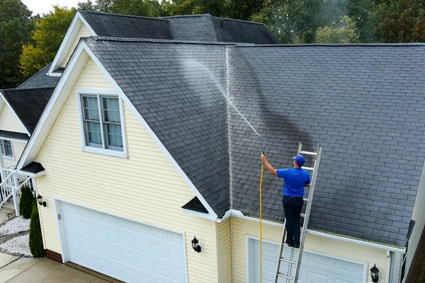 A Diamond Touch technician gently soft washing a home's roof